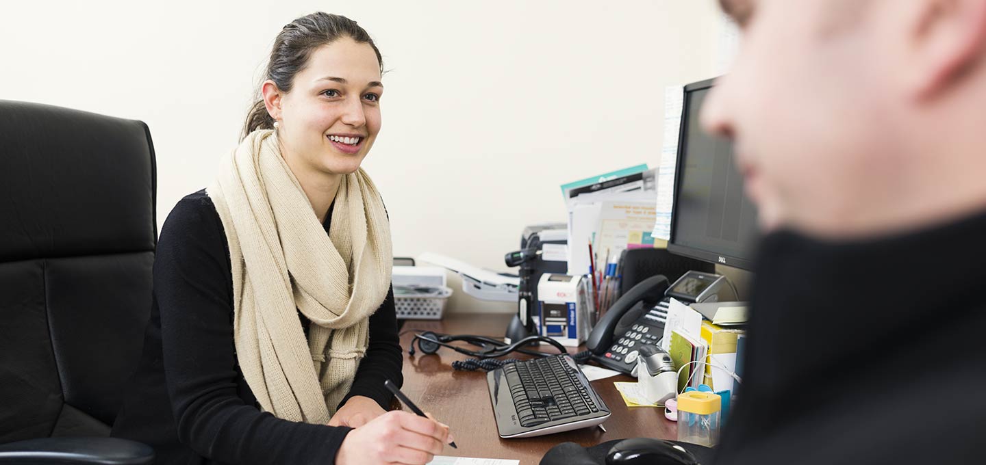 A receptionist at the clinic desk
