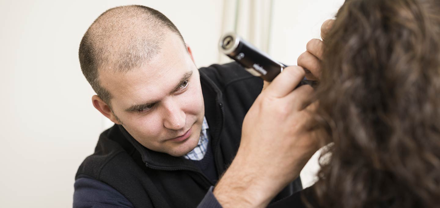 A clinician examining a patient's ear