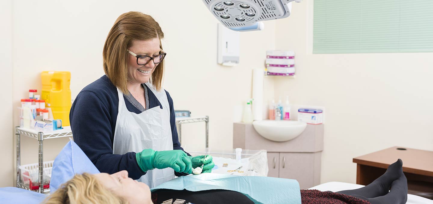 A nurse with a patient during a procedure in the treatment room.